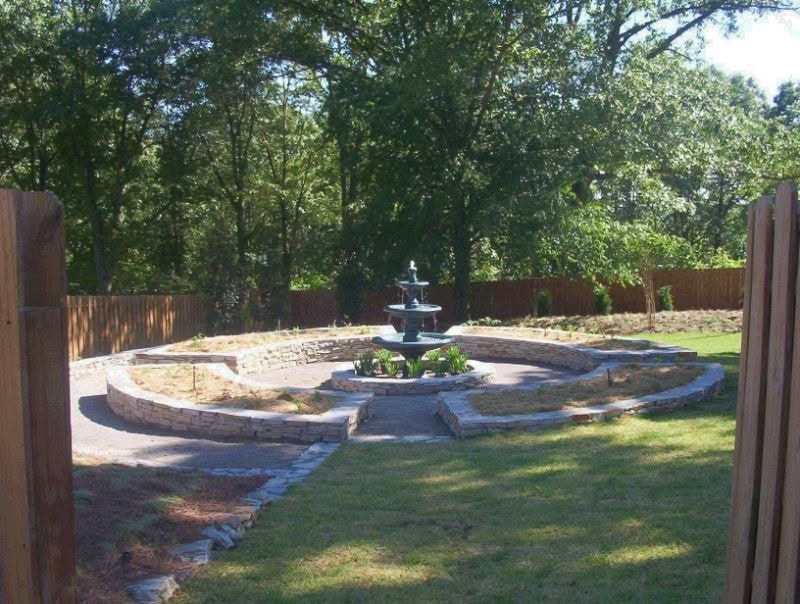 Elegant backyard landscape with tiered fountain and stone pathways by John Russell Landscape Architect.