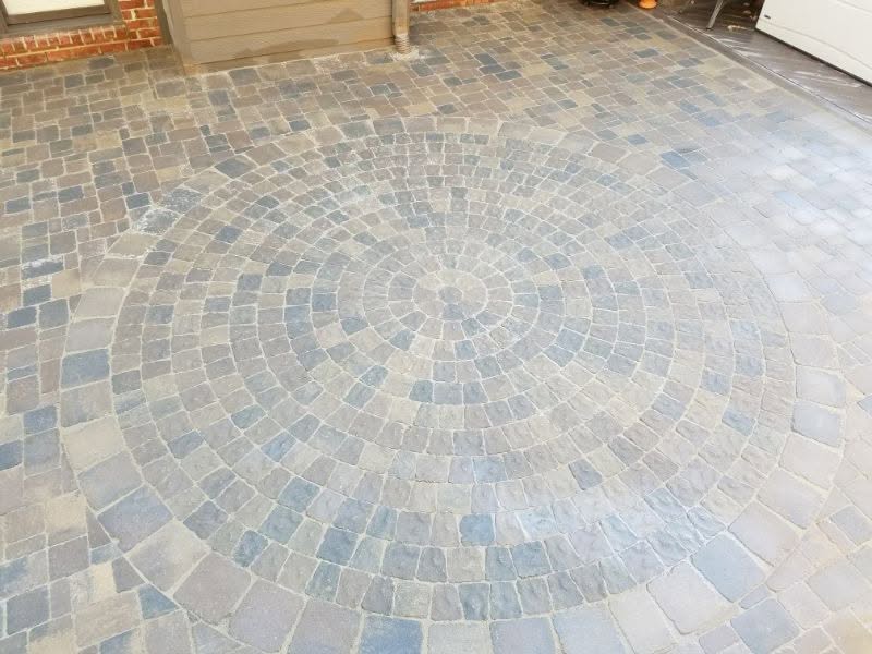 Patterned stone paver patio with circular design by John Russell Landscape Architect. Custom outdoor living space featuring durable, decorative landscape architecture.