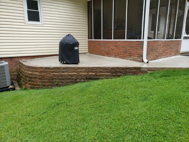 Modern backyard patio with brick step design and lush green lawn, ideal for outdoor living and landscaping by John Russell Landscape Architect.