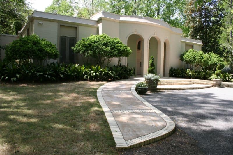 Modern residential landscape with elegant entrance, curved walkway, and lush greenery, designed by John Russell Landscape Architect. Perfect for enhancing curb appeal and outdoor aesthetics.