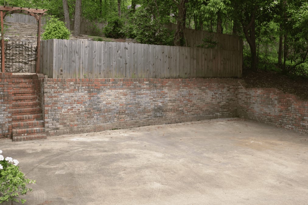 Brick and wood retaining wall with landscaped yard, outdoor patio design, landscape architecture by John Russell Landscape Architect, garden landscape planning, backyard renovation.
