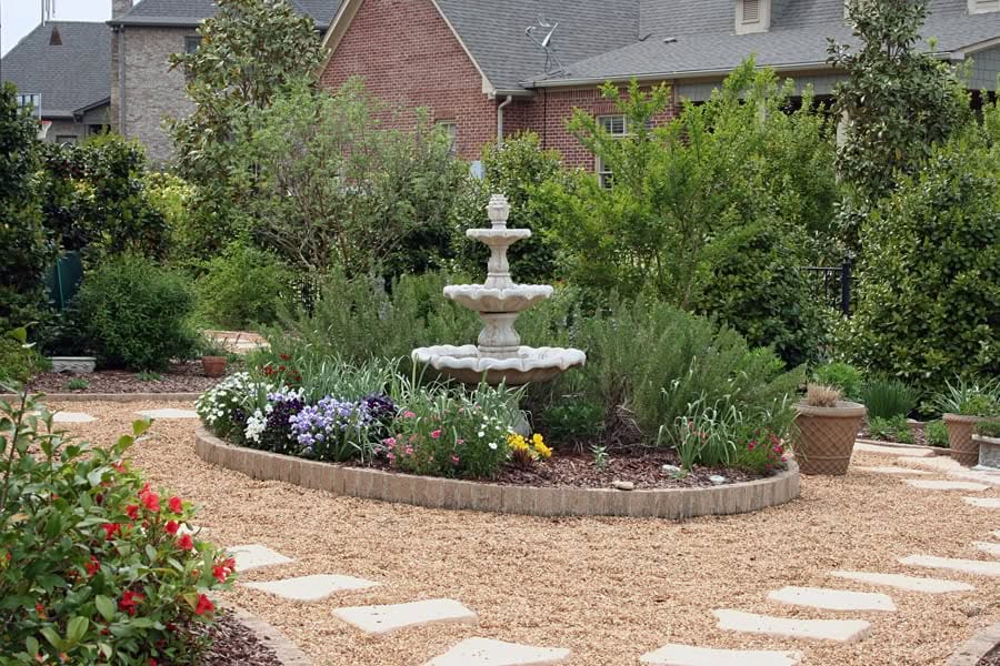Elegant garden courtyard with tiered fountain and lush greenery, designed by John Russell Landscape Architect for outdoor beauty and serene landscape architecture.