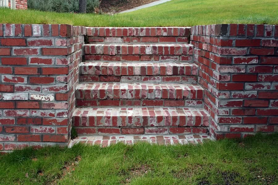 Red brick garden staircase with brick planters, built by John Russell Landscape Architect, showcasing durable brickwork and landscape design.