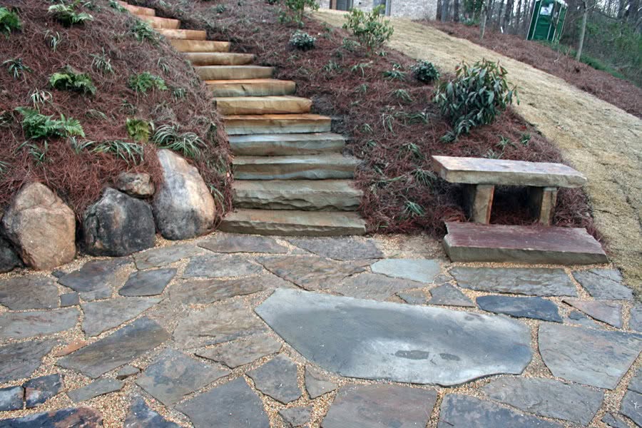Stone steps and landscaped garden design by John Russell Landscape Architect, featuring natural stone materials, erosion control, and outdoor seating for a picturesque garden environment.