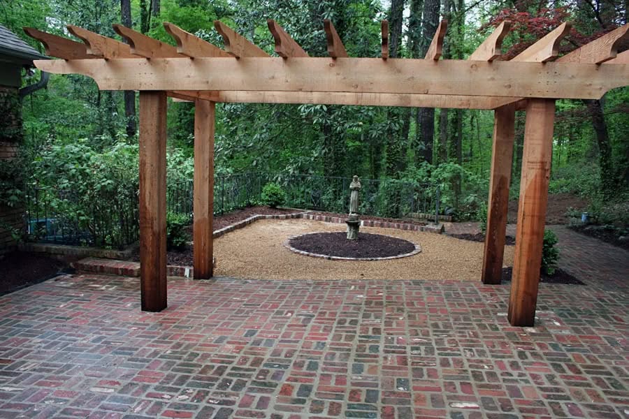 Pergola landscape design with brick patio, garden fountain, and lush greenery - John Russell Landscape Architect.