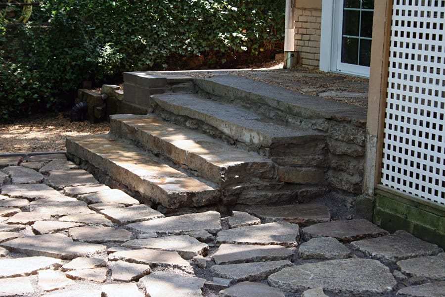 Natural stone outdoor stairs with rustic design, leading from house to garden, crafted by John Russell Landscape Architect, enhancing landscape aesthetics and functionality.