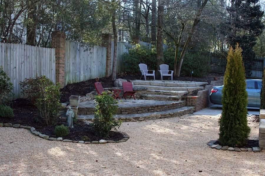 Designing outdoor landscapes with stone patios and seating areas for relaxing gardens.