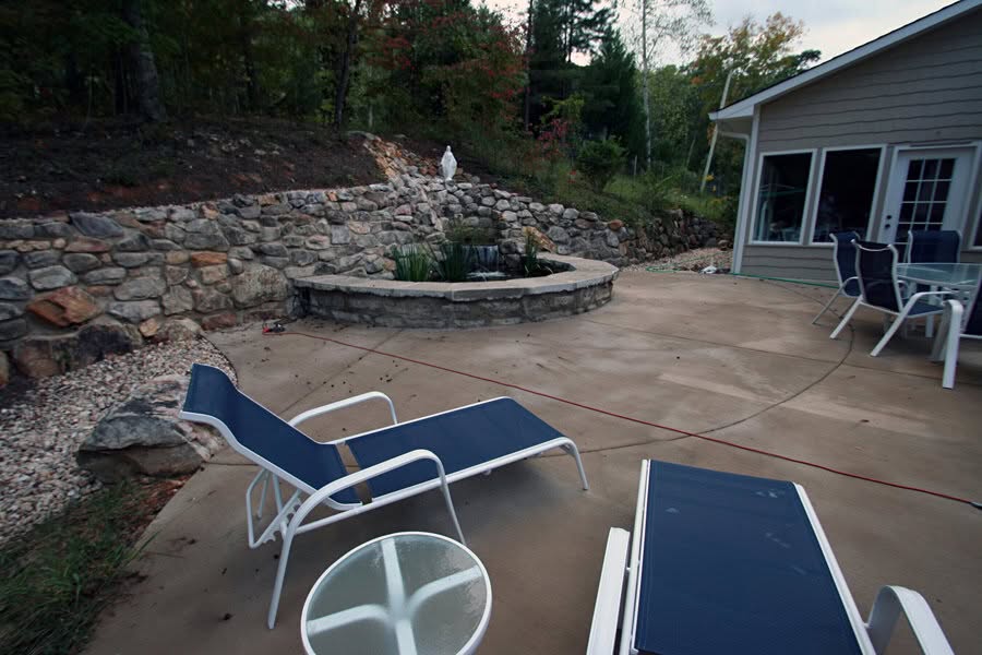 Fire pit landscape design with stone retaining wall, outdoor patio, and seating area at john russell landscape architect.