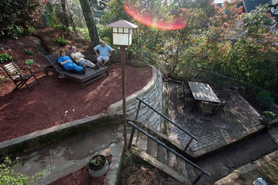 Picture of an outdoor garden seating area with trees and a brick patio, designed by John Russell Landscape Architect, showcasing landscape architecture and garden design services in a backyard setting.