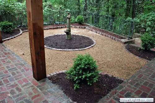 Artificial landscape garden with brick patio and manicured shrub, designed by John Russell Landscape Architect, showcasing customized outdoor space for relaxation and aesthetic appeal.